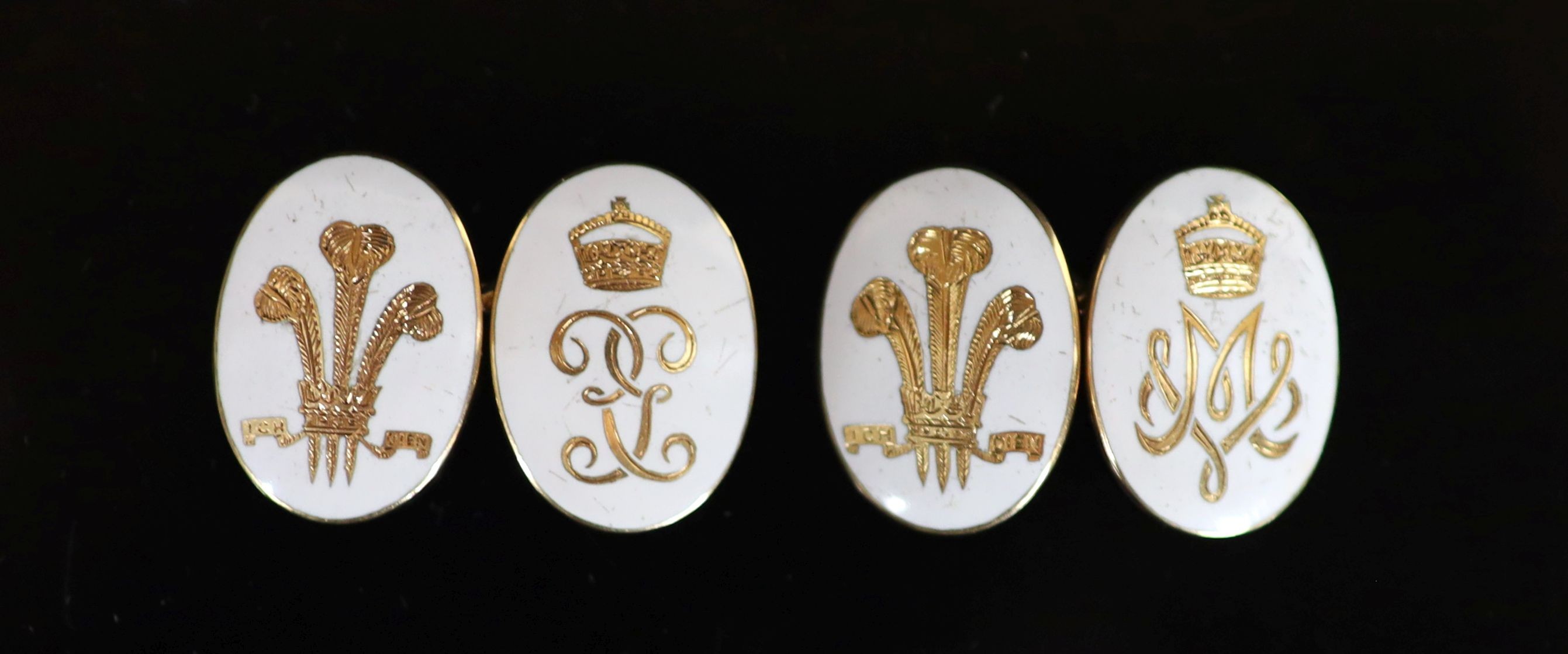A pair of gold and white enamel oval cufflinks, each gilded with Prince of Wales Feathers and monogram below a coronet